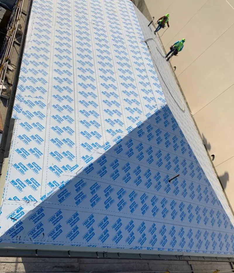 Professional roofers installing underlayment on a metal roof in Williamsville